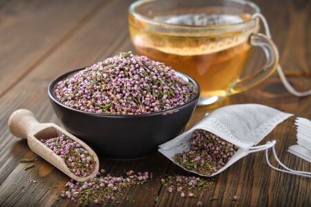 Glass tea cup with herbal teabag inside on wooden table.の写真素材