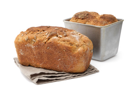 Homemade bread and freshly baked loaf in baking tin on background.の写真素材