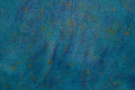 Watercolor background in deep blue color with green tone and yellow paint splatter.の写真素材