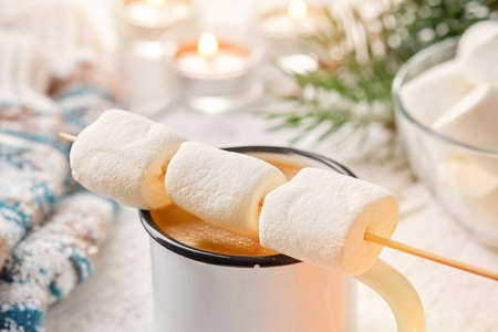 Hot coffee or chocolate mug and skewer with marshmallow  for roasting. The concept of cosy holidays and winter.の写真素材