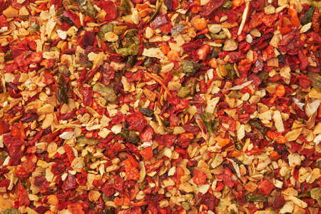 Spice mix for cooking dishes. Flakes of red hot pepper, paprika, garlic, onion. Dried seasoning closeup. Top view.の写真素材