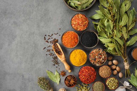 Bowls of various spices - red hot pepper, paprika, anise, saffron, black seeds, nutmegs, cardamom pods, thyme, gloves, coriander, curcuma, cinnamon, laurel. Different seasoning for cooking. Ayurveda remedies.の写真素材