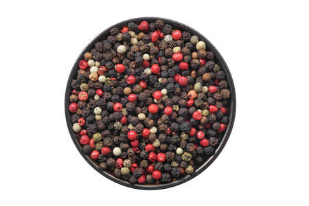 Bowl of dried aromatic peppercorns, isolated on white. Colourful pepper mix - black, red, green and white peppercorns. Top view.の写真素材