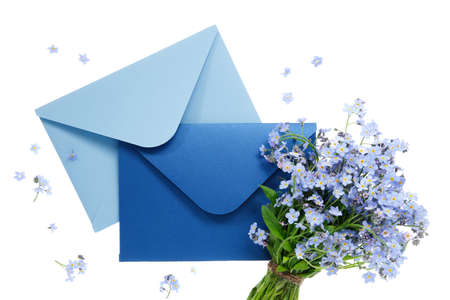 Blue envelope with wedding invitation card or birthday letter decorated with bouquet of wild forget me not flowers on white. Flat lay. Top view.の写真素材