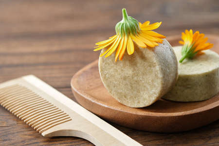 Natural organic calendula solid shampoo pieces, calendula flower and wooden hair comb. selective focus.の写真素材