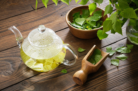 Glass teapot with birch leaf tea. Tea Herbal tea kettle and bowl of leaves of Birch tree. alternative herbal medicine.の写真素材