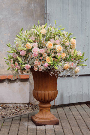 Luxurious bouquet of roses, lilies and gypsophila flowers in a classic large vase.の写真素材
