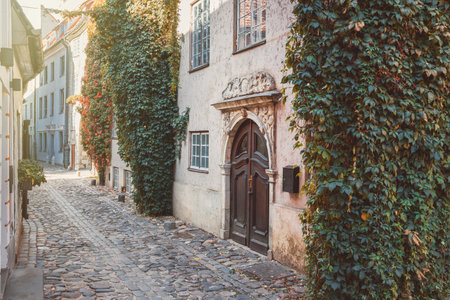 Old medieval narrow street in the fall. Old town of Riga, Latvia. Retro styled.の写真素材