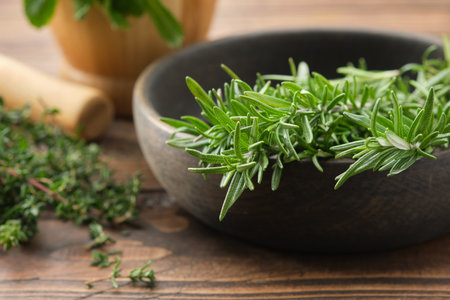 Bowl of fresh rosemary medicinal herbs. Twigs of thyme and mint on background. Healing herbs, Healthy cooking seasonings. Alternative medicine and healthy food.の写真素材