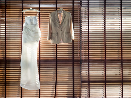 Wedding dress hanging on the wooden curtainの写真素材