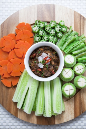 Thai styled Chilli sauce and vegetables on wooden plate の写真素材