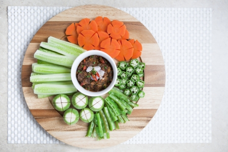 Thai styled Chilli sauce and vegetables on wooden plate の写真素材