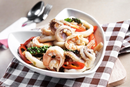 Sizzling spicy fried squid and shrimp on fabric plaid の写真素材