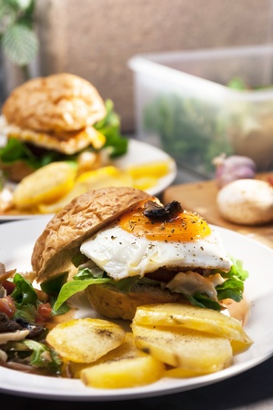 Egg burger , salad , boiled potatoes on kitchen background の写真素材