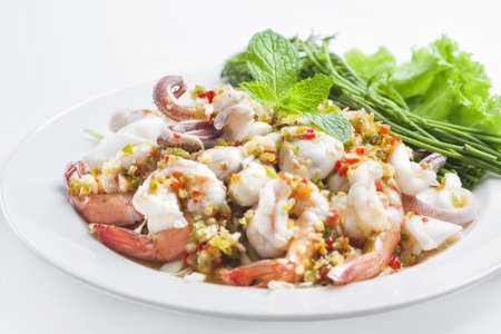 Spicy seafood salad , prawns , squid , oyster on white backroundの写真素材
