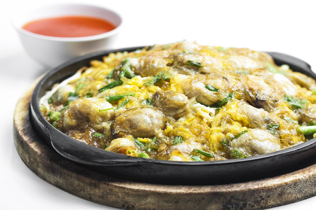 Oysters fried in egg batter on pan and white background の写真素材