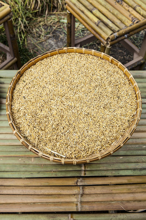 Paddy in pannier on bamboo table の写真素材
