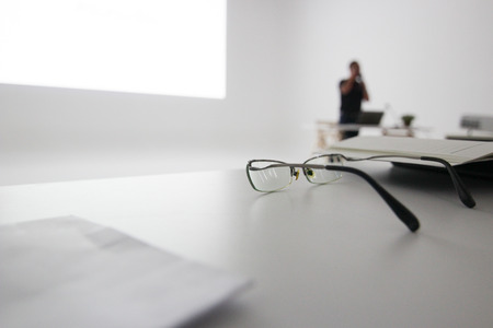 glasses on table of seminar room, selective focus, education concept.の写真素材