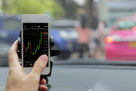 business man trade and check graph forex in stock market exchange money on mobilephone during drive...