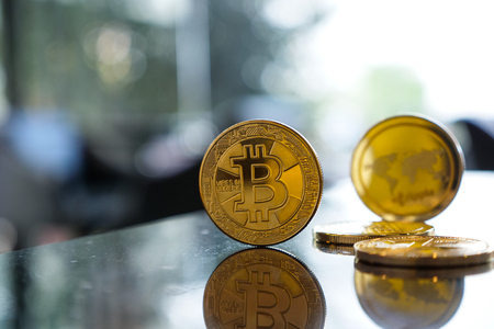 bitcoin and reflex on table, bokeh background with copyspace. cryptocurrency concept.