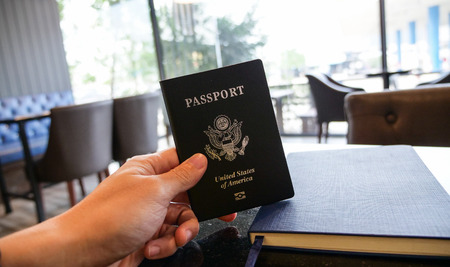 hand holding passport and restaurant background. travel concept.の写真素材