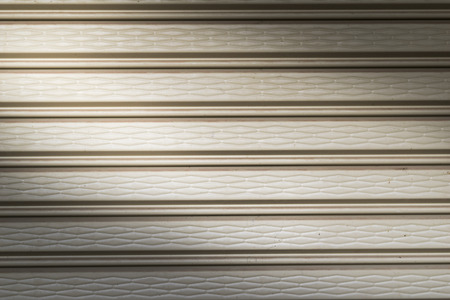 illuminated grunge metallic roller auto shutter door with light from corner