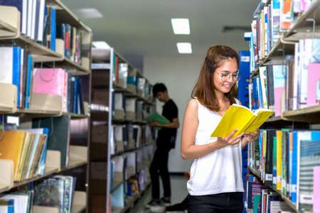 Young Student Girl Reading Book in Classroom Education Libraryの写真素材