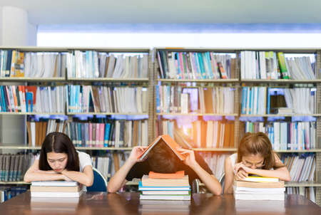 Young Student Group seriously with Her Exam and reading book in Libraryの写真素材
