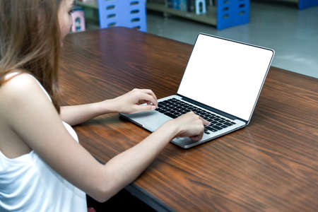 Young Girl using Laptop Computer on Table in Library Room with White Isolated Background Product , Cliping Pathの写真素材