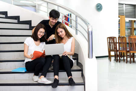 Young Student Group Reading Book and Using Laptop Computer Smile in Classroom Education Library...