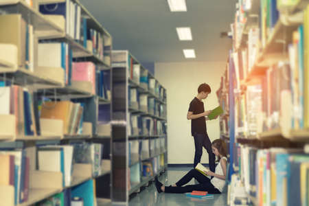 Young Student Asian Together Teenager with school folders reading book at library university campus college knowledge centerの写真素材