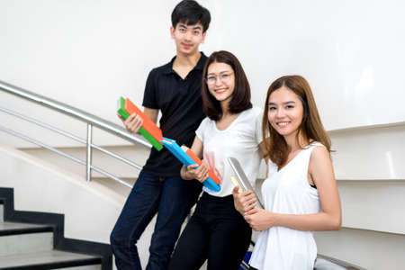 Young Student Group Holding Book and Laptop Computer Smile in Classroom Education Library Universityの写真素材