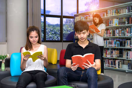 Young Student Asian Group teenager reading book with school folders at library university campus college knowledge centerの写真素材