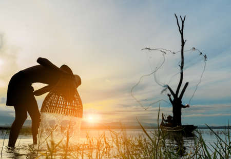 Children Fisherman boy with catching fish and fisherman throwing nets and girl on boat on lake river thailandの写真素材