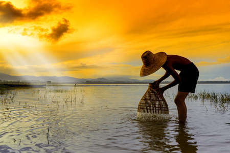 Children Fisherman boy with catching fish on lake river thailandの写真素材