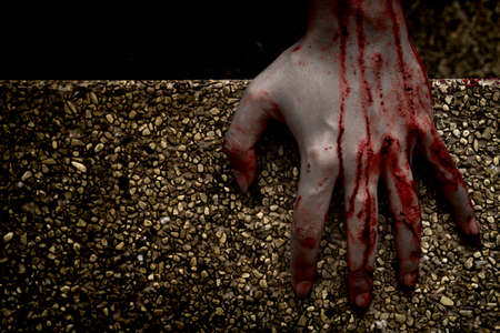 Hand zombie death with blood touching stair on nightmare darkness background, horror halloween festival conceptの写真素材