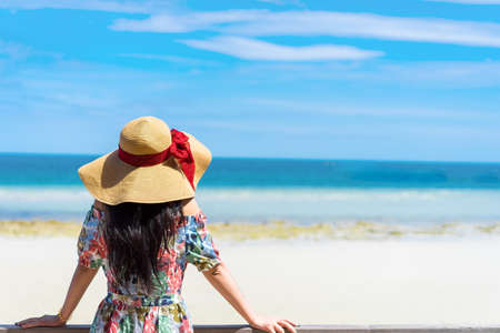 Young asian girl in hawaii dress with hat and sunglasses on the beach summer fun and happy relax in vacation timeの写真素材