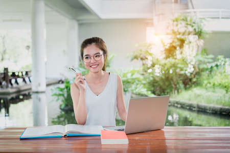 Young Student Girl Homework with Laptop Computer Happy and Fun in Classroom Education Libraryの写真素材