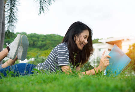 Asian young girl reading book relax on parkの写真素材