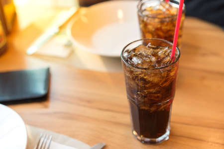 Double soft drink carbonated fresh food soda, white dish on wooden table with handsome man sitting  brown sofa in pizzeria restaurantの写真素材