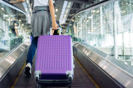Young girl travel walking with carrying hold suitcase luggage and passenger for tour travel booking ticket flight in airport international vacation time in holiday rest and relaxation.の写真素材