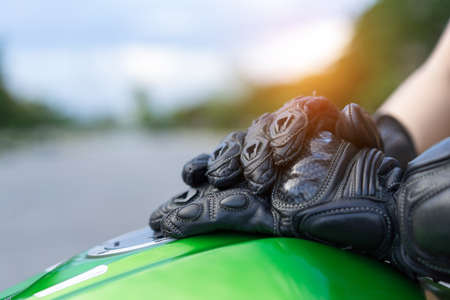 Closeup woman biker with glove safety ride acceleration speed control, hand holing handbrake on motorcycle vehicle and nature background.の写真素材
