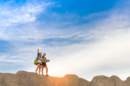 Young girl asian together with backpack and open maps on the mountain looking location to...