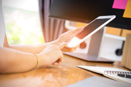 Closeup,Young girl freelancer business private working at home office using tablet with note and packaging delivery online market on purchase orders to customerの写真素材