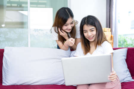 Young asian girl together teamwork freelancer business private working at home office using laptop packaging delivery online market on purchase checking orders to customer.の写真素材