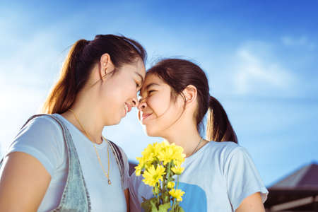 Family mother kissing daughter with hugging on sunlight happy lover in summer outdoor and homeの写真素材