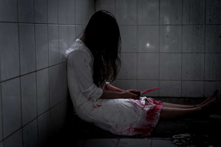 Ghost woman or zombie holding knife for kill yourself with blood violence in house of ruin,...