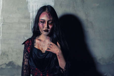 Zombie women death or witch the ghost with blood skin is screaming darkness and nightmare background, horror of scary fear on hell is monster devil girl in halloween festival conceptの写真素材