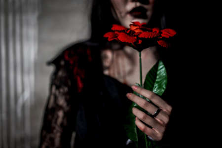 Witch woman death holding rose  the ghost with blood skin is screaming darkness and nightmare background, horror of scary fear on hell is monster devil girl in halloween festival conceptの写真素材