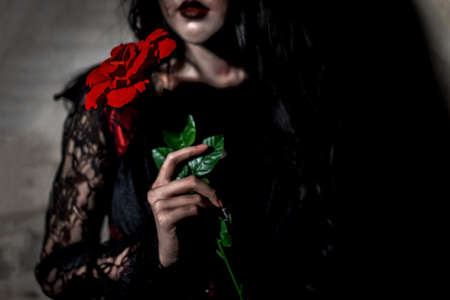 Witch woman death holding rose  the ghost with blood skin is screaming darkness and nightmare background, horror of scary fear on hell is monster devil girl in halloween festival conceptの写真素材